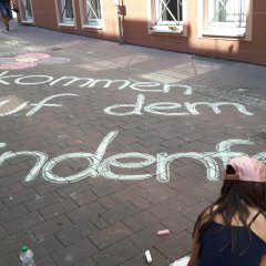 "Willkommen zum Lindenfest" Schriftzug auf der Straße, mit Kreide geschrieben