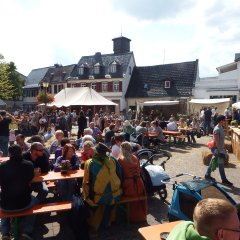 Menschen sitzen an Tischen auf dem Stadtspektakel