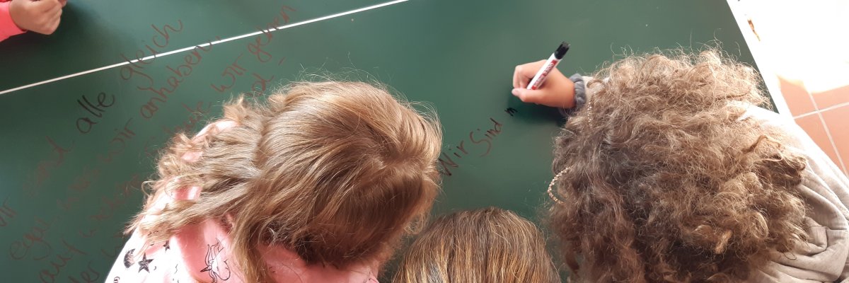 Kinder beugen sich über eine Tischtennisplatte