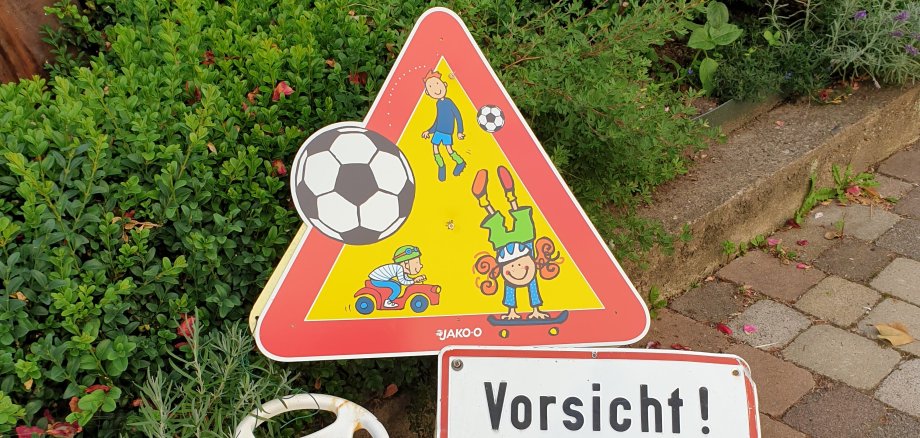 Schild Vorsicht Spielend Kinder mit einem bobycar davor