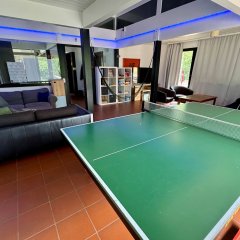 Innenraum mit Tischtennisplatte, Sofas, Sitzbereich und Hängematte.