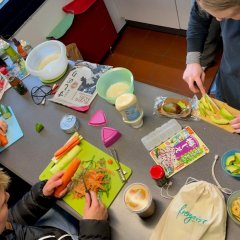 Kinder und Jugendliche bereiten gemeinsam Essen in der Küche zu.