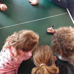 Kinder über einer Tischtennisplatte gebeugt