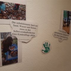 Ein Papier, mit der Aufschrift: "Das unbekümmerte Spiel mit Sand, Wasser und Steinen muss zu den Selbstverständlichkeiten eines Kinderalltags zählen"