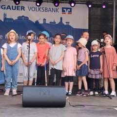 Kinder singen etwas auf einer Bühne