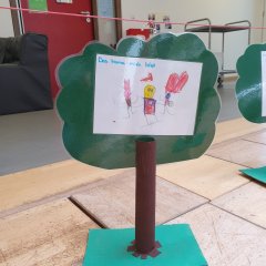 Baum aus Holz mit einem gemalten Bild auf dem steht: "Das Mama mich liebt"