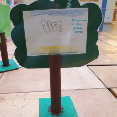 Baum aus Holz mit einem gemalten Bild auf dem steht: "Zusammen in den Urlaub fahren"