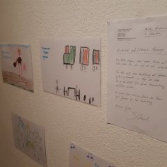 gemalte Bilder von Kindern an die Wand gehängt