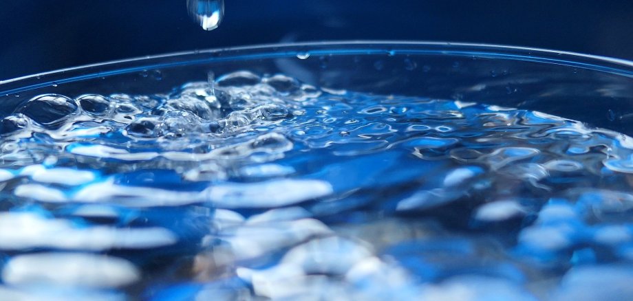 Wasser tropft in ein Glas