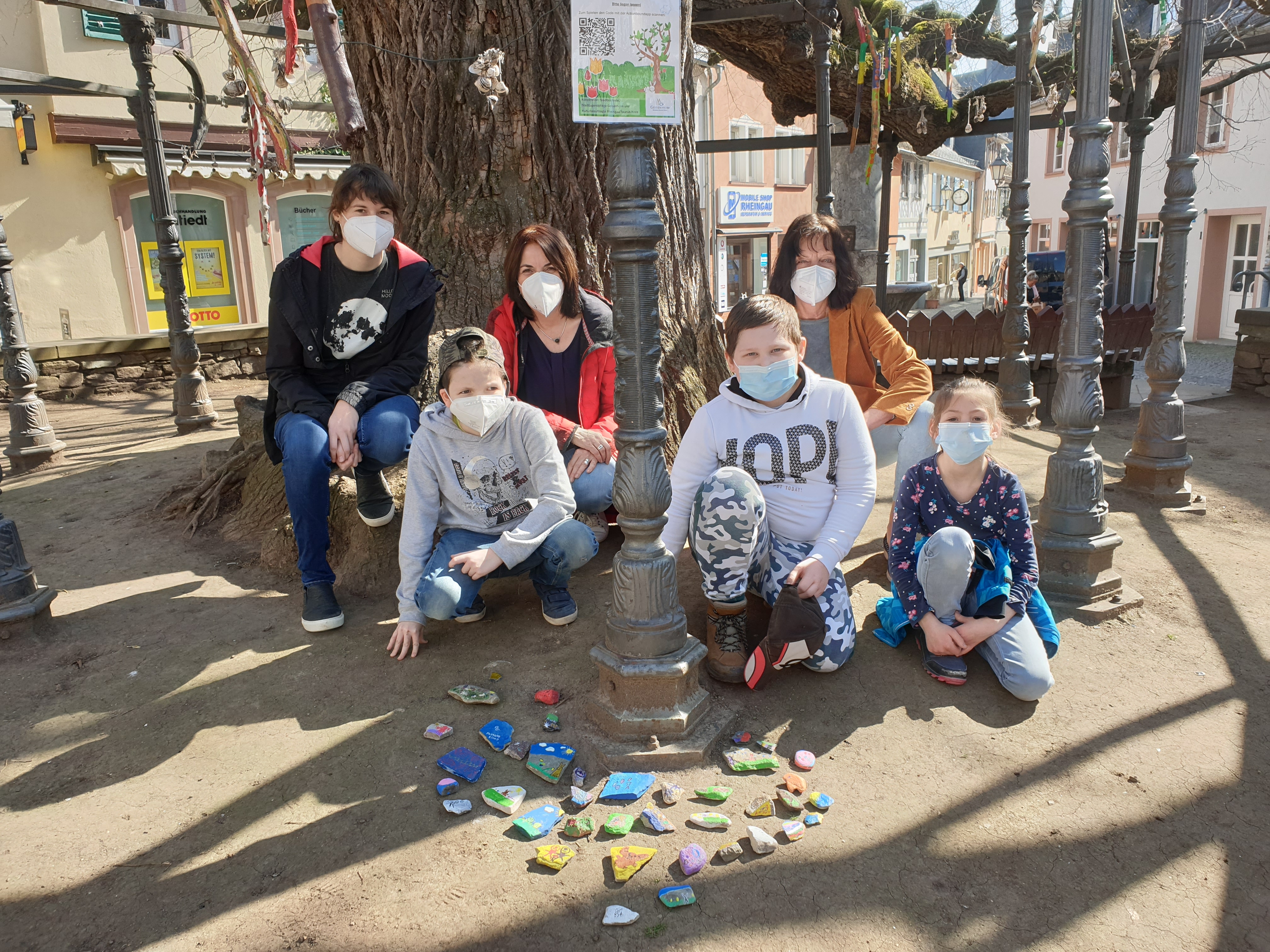 Bild: Annemarie Freudenberg (Stadtjugendpflege), Christiane Gortner (Stadtbücherei) und Petra Aisslinger mit Kindern der Leopold-Bausinger-Schule, die für den Actionbound Steine bemalt haben.