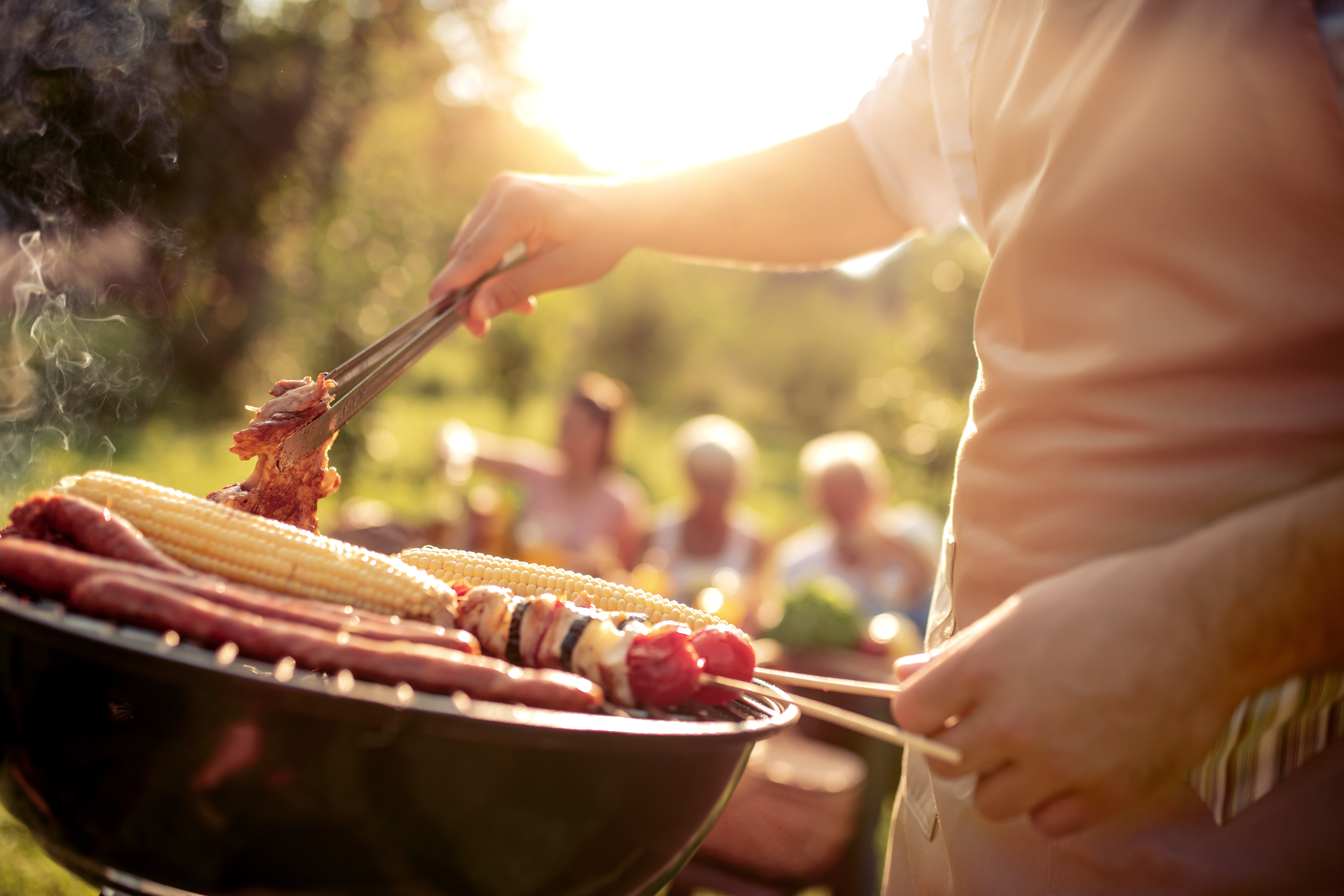Man preparing food on garden barbecue