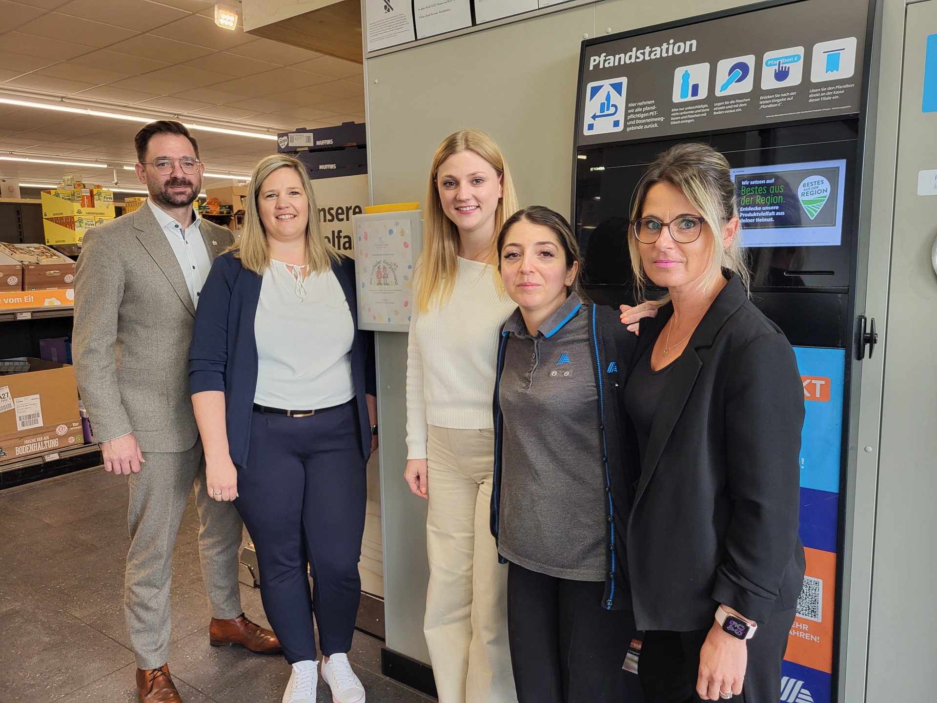 Bürgermeister Christian Aßmann, Nicole Rakusa (Leiterin Kindertagesstätte Marienthaler Knirpsenland), Alexandra Albes (Regionalverkaufsleiterin ALDI Süd), Marta Sakur (stellvertretende Filialleiterin) sowie Christina Roleder (Leiterin Amt für Bürger und Soziales) in der ALDI Filiale Rüdesheim