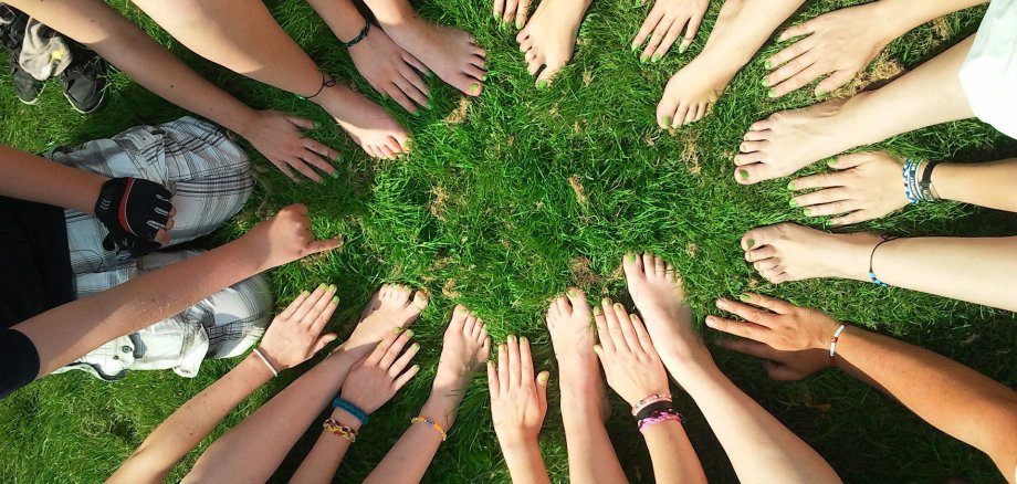 Kinder Hände und Füße in einem Kreis im Gras