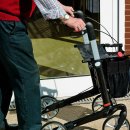 Mann schiebt einen Rollator
