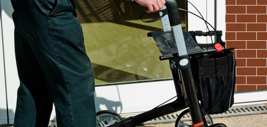 Mann schiebt einen Rollator
