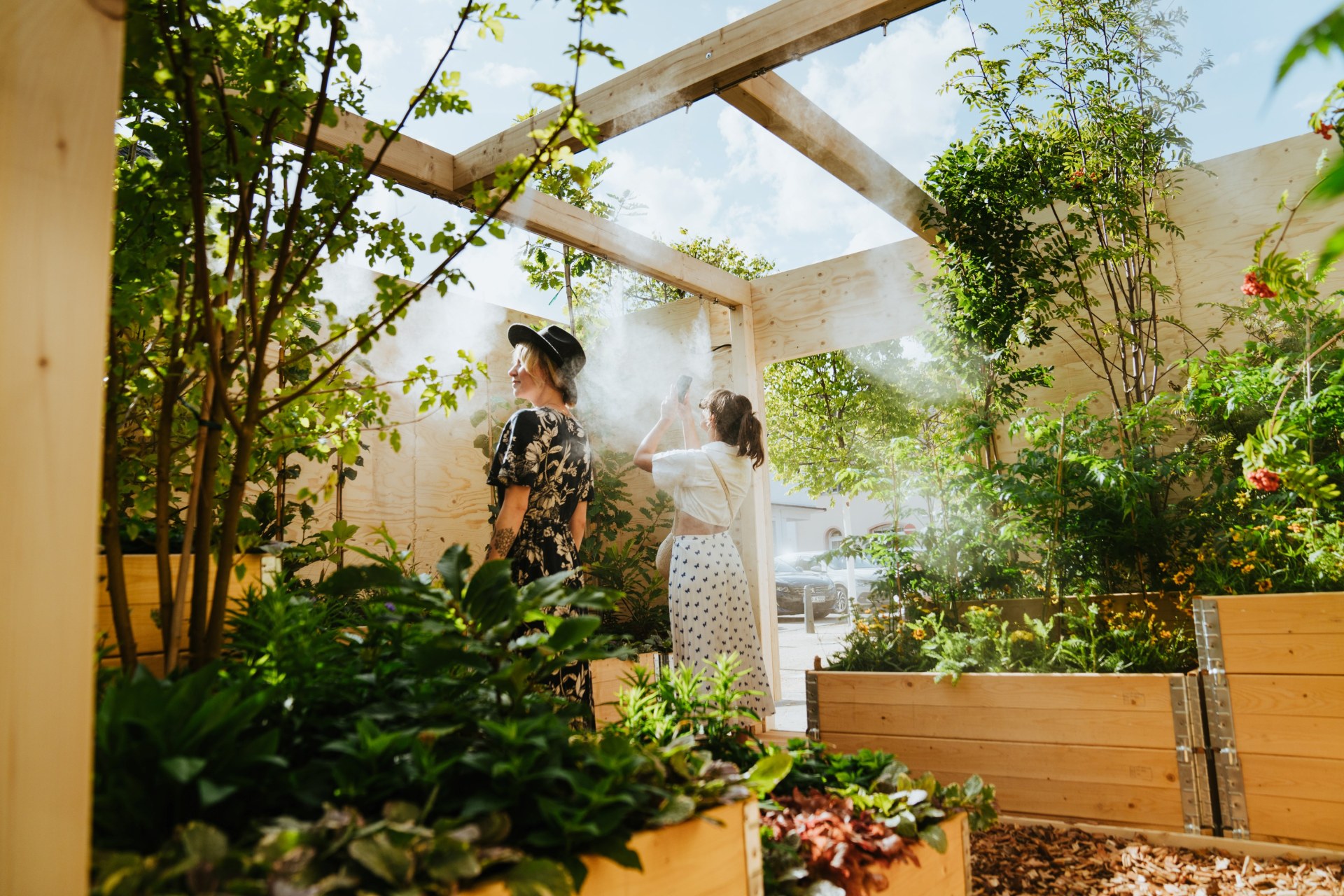 Die Klima-Kiste Geisenheim von innen. Viele Pflanzen. Zwei Frauen sehen sich um.