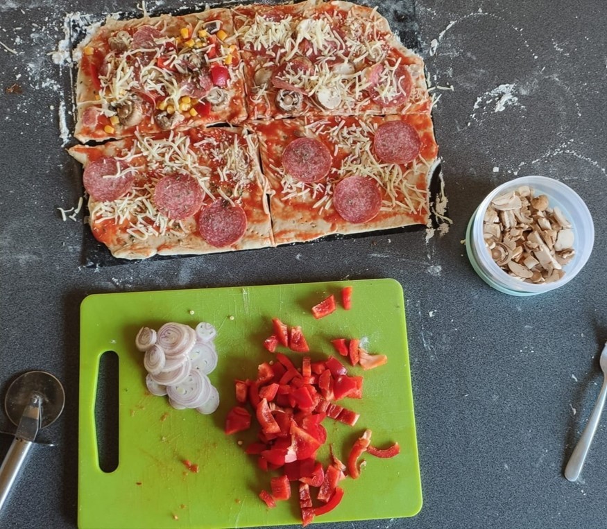 Pizza und eine Schale mit Pilzen