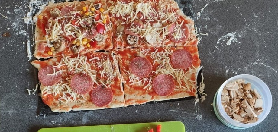 Pizza und eine Schale mit Pilzen