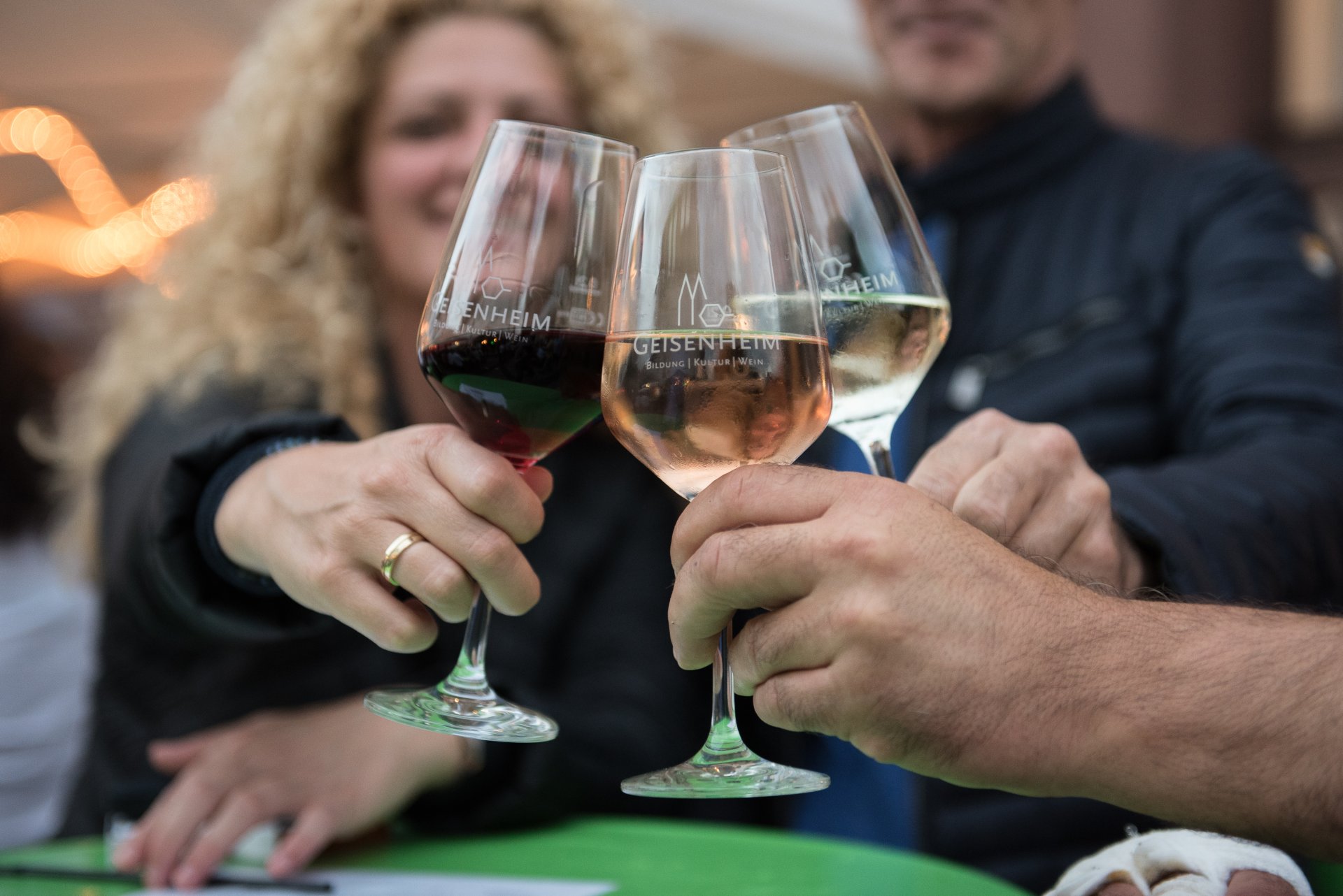 Drei Personen stoßen miteinander an