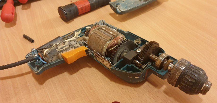 Bohrmaschine auseinandergebaut auf Tisch liegend