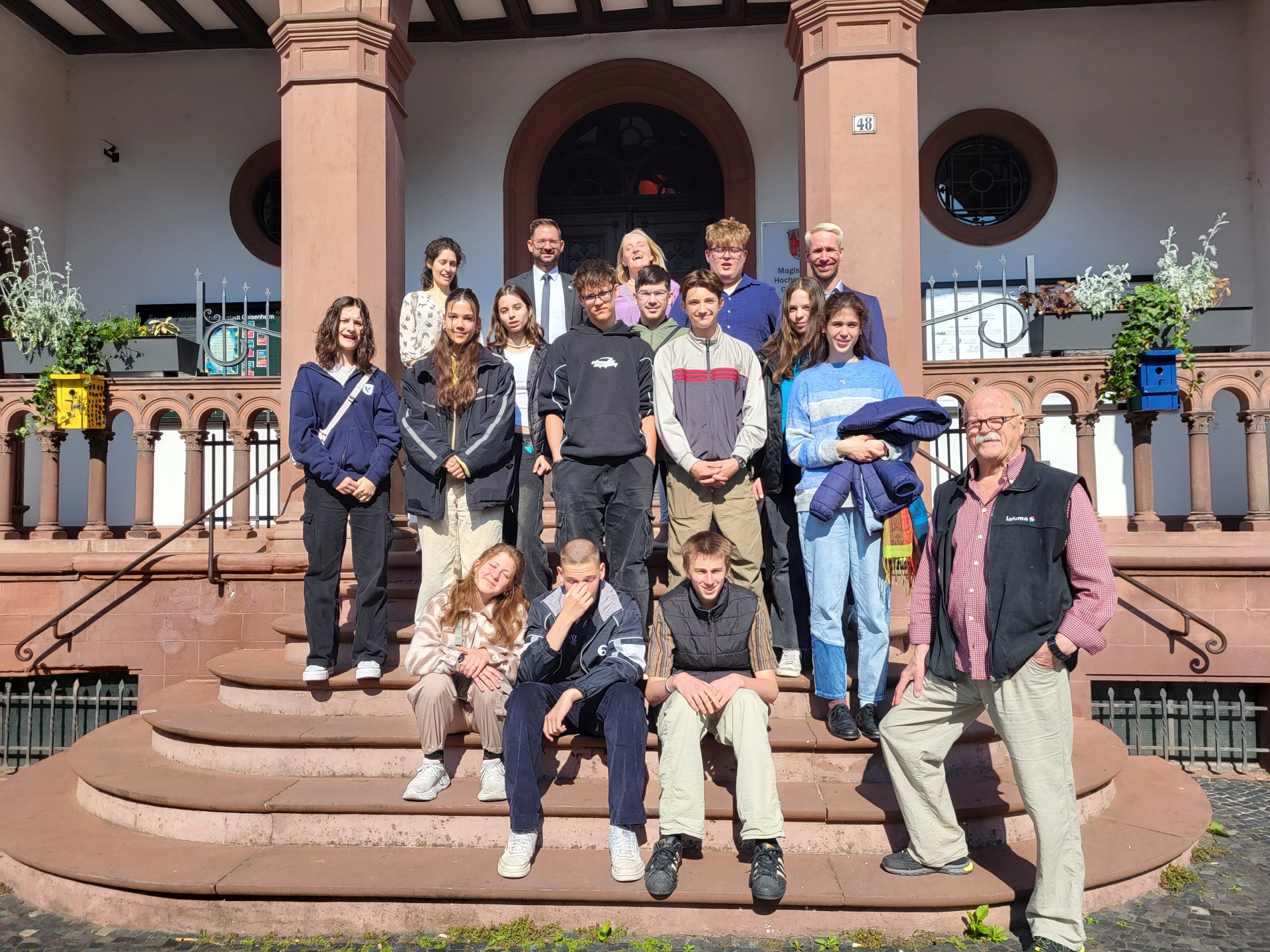 Gruppe ungarischer Schüler und Schülerinnen mit Lehrkräften zusammen mit Bürgermeister Christian Aßmann und Istvan Szàsz auf der Rathaustreppe