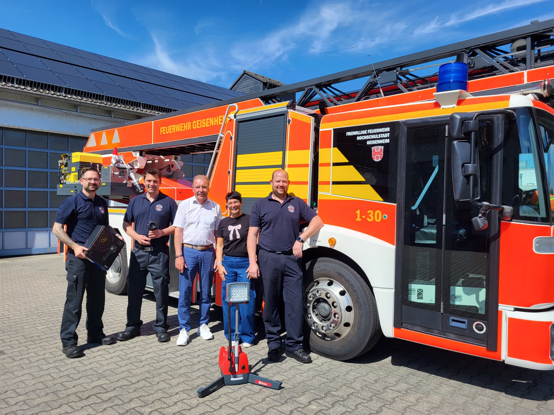 Gruppenbild mit Feuerwehrdrehleiterfahrzeug und LED Leuchte