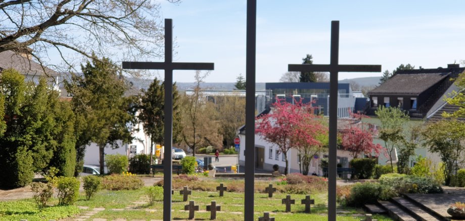 Kreuze auf dem Ehrenfriedhof Geisenheim mit der Stadt im Hintergrund