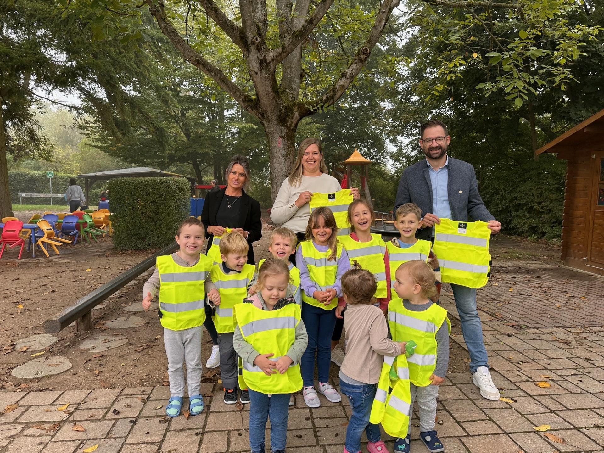 Übergabe der Sicherheitswesten in der Kita Marienthaler Knirpsenland mit Leiterin Nicole Ra-kusa (Mitte), Leiterin Amt für Soziales Christina Roleder (links) und Bürgermeister Christian Aßmann.