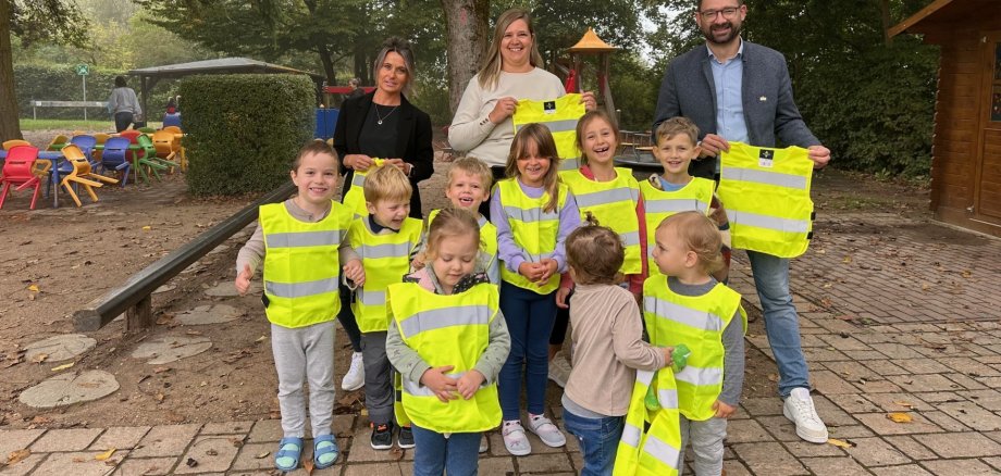 Übergabe der Sicherheitswesten in der Kita Marienthaler Knirpsenland mit Leiterin Nicole Ra-kusa (Mitte), Leiterin Amt für Soziales Christina Roleder (links) und Bürgermeister Christian Aßmann.