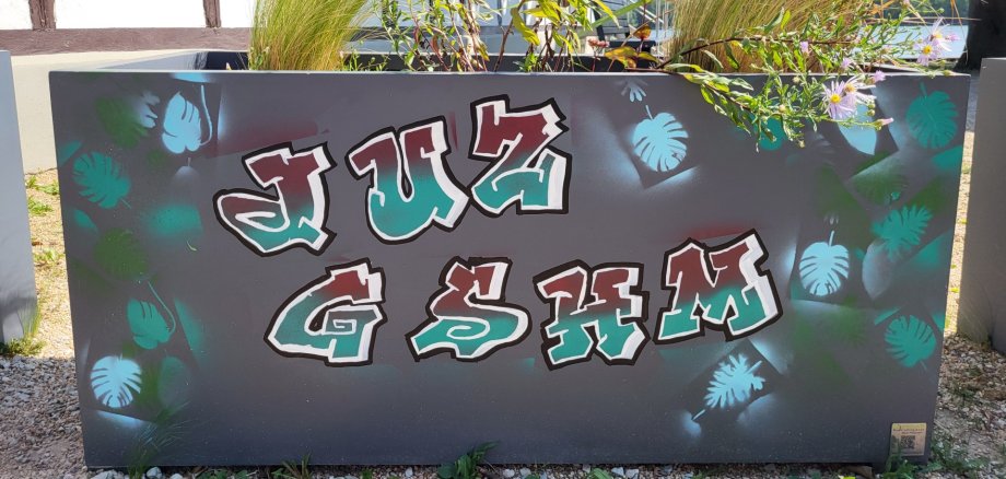 Schriftzug JUZ Geisenheim, auf einem Blumenkasten, als Graffiti