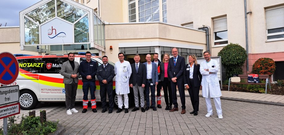 Nachhaltige Verbesserung der Notarztversorgung im Rheingau: Landrat Sandro Zehner stellt mit dem Team des Josefs-Hospital Rheingau und den Maltesern den neuen Standort für das  Notarzteinsatzfahrzeug in Rund-um-die-Uhr-Bereitschaft ab Januar 2026 in Rüdesheim vor. Foto: Rheingau-Taunus-Kreis