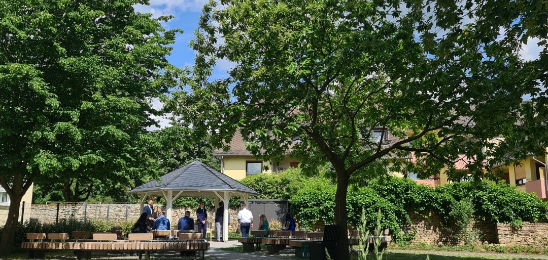 Grüne Parkanlage in Geisenheim mit Pavillon und Besucherinnen und Besuchern.
