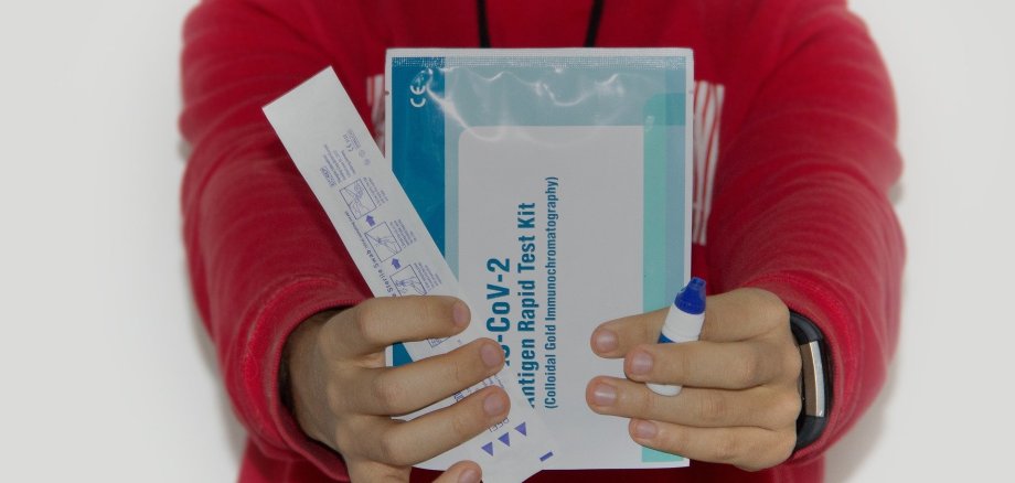 Person, die Corona Tests hält
