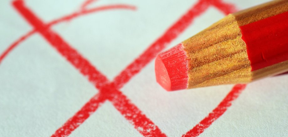 roter Stift, der ein Kreuz gemalt hat