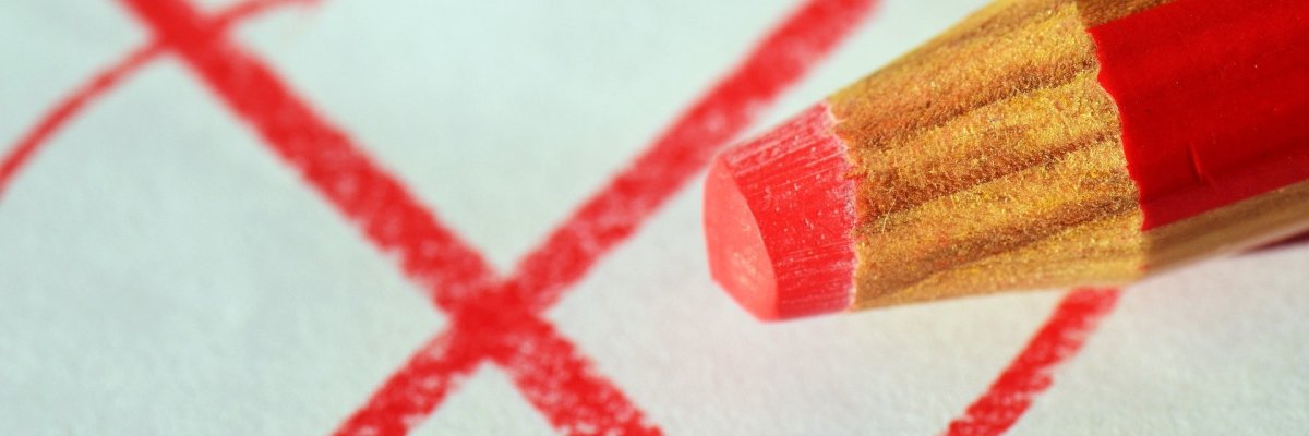 roter Stift, der ein Kreuz gemalt hat