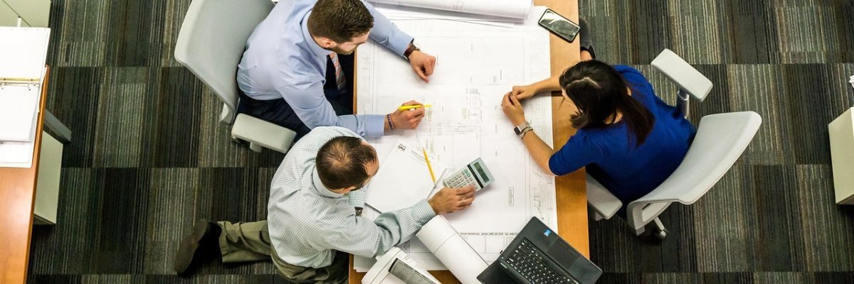 Menschen an einem Besprechungstisch von oben