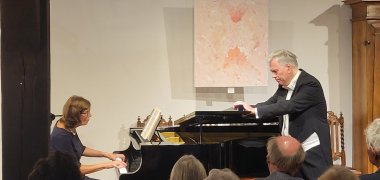 Maria Sofianska am Flügel und Frank Günther stehend am Konzertabend während des Auftritts