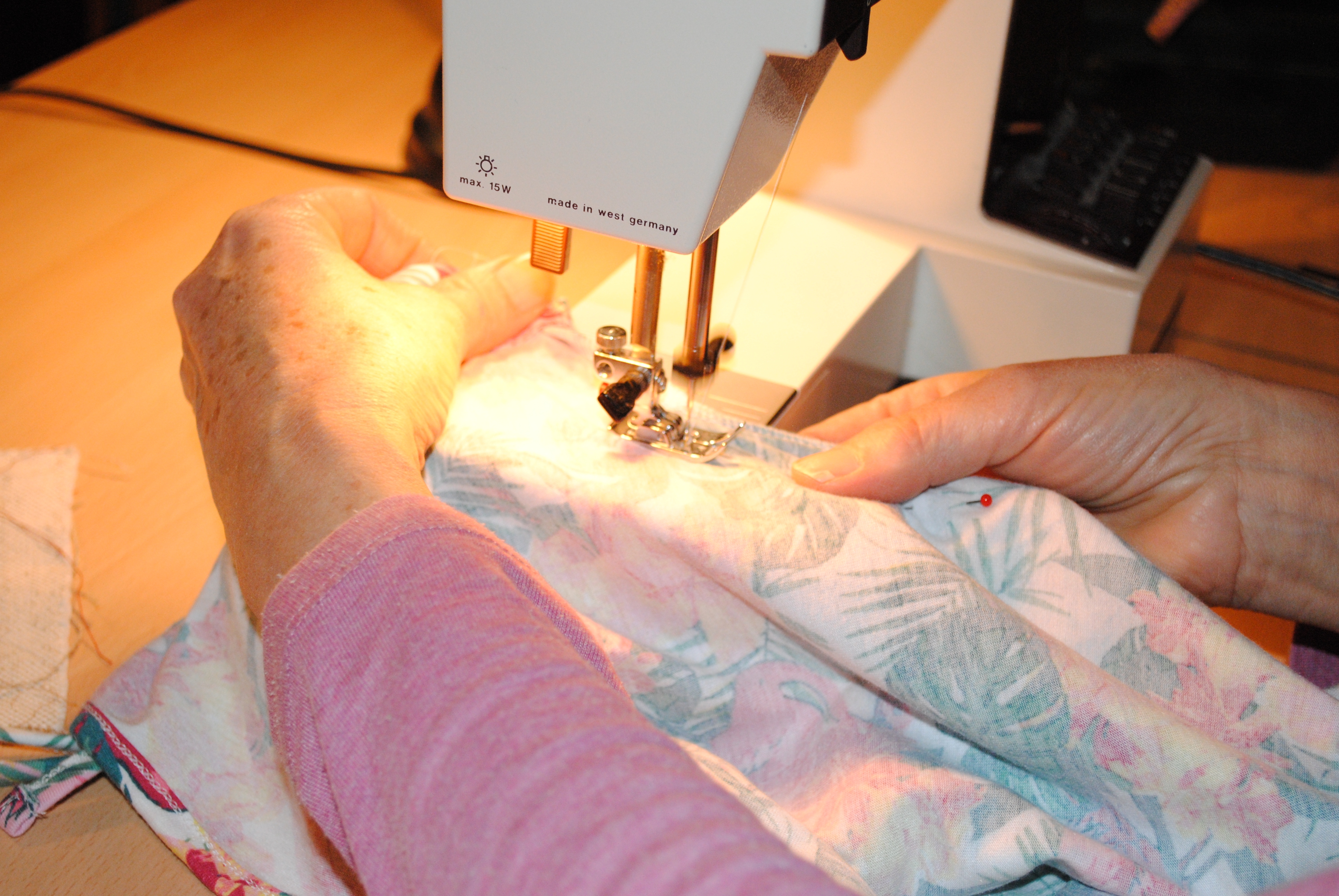 Ein Stoffstück wird mit einer Nähmaschine genäht