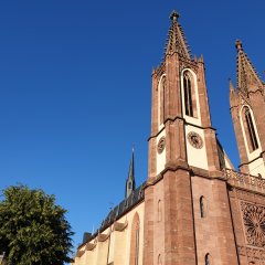 Pfarrkirche Heilig Kreuz mit den zwei Türmen vor blauem Himmel