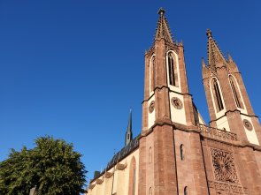 Pfarrkirche Heilig Kreuz mit den zwei Türmen vor blauem Himmel